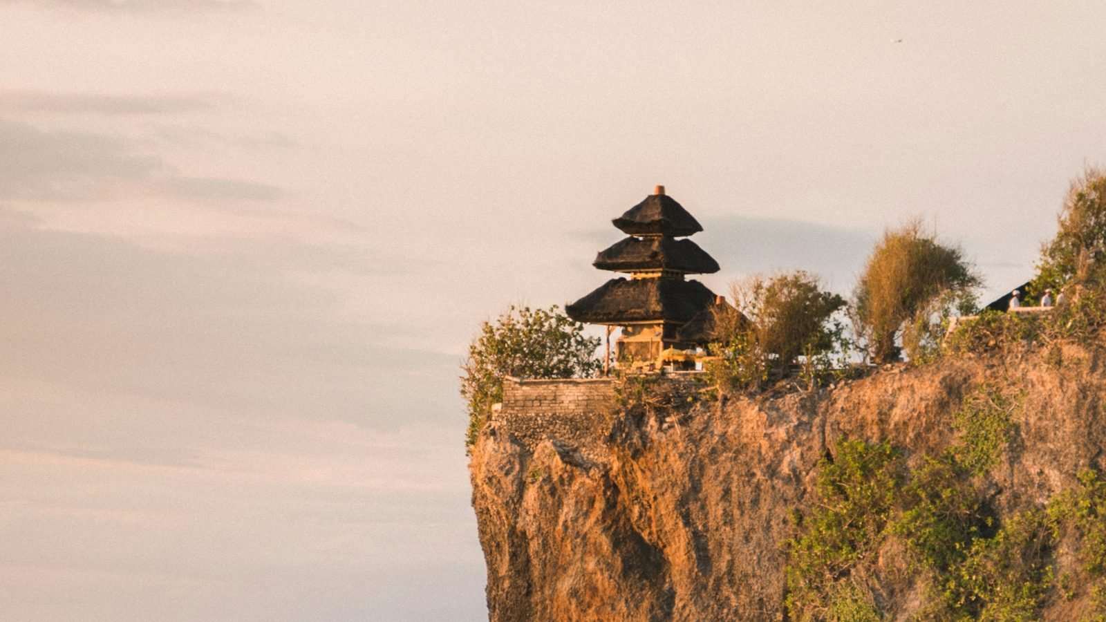 Świątynia na szczycie klifu Uluwatu nad oceanem o zachodzie słońca